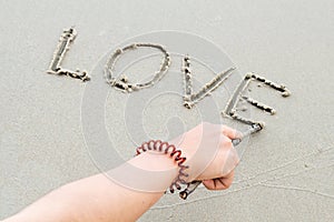 Write the word love letters on the sand