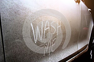 Write the words `wash me` on the very dirty surface of the car.