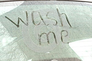 Write the words wash me on the very dirty surface of the car. Concept car wash