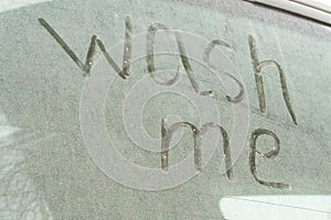 Write the words wash me on the very dirty surface of the car. Concept car wash