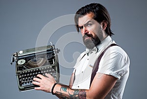 He is a writer. brutal guy in bow tie. elegant male typist. handsome hipster use technology in modern life. mature