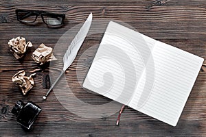 Writer concept. Feather pen, vintage notebook and crumpled paper on wooden table background top view copyspace mockup