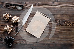 Writer concept. Feather pen, vintage notebook and crumpled paper on wooden table background top view copyspace mockup