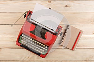 Writer or journalist workplace - vintage red typewriter on the wooden desk