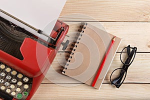 Writer or journalist workplace - vintage red typewriter on the wooden desk