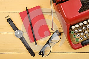 Writer or journalist workplace - vintage red typewriter on the yellow wooden desk