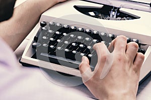 Writer typing with retro writing machine. Old typewriter