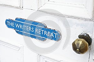 Writers retreat door sign at entrance to quiet peace room for mindfulness and thinking writing zone