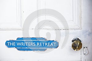 Writers retreat door sign at entrance to quiet room on white weather oak door distressed paint photo