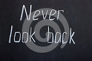 Writing on the black board `never look back`