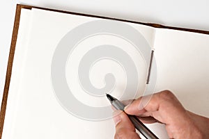 Blank notebook with hand holding pen