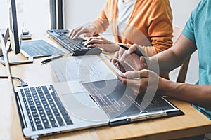 Writing codes and typing data code technology, Programmer cooperating working on web site project in a software developing on