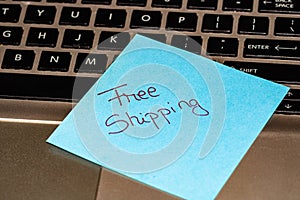 Writing on colorful sticky note Free Shipping. Text with Free Shipping on paper. Sticky note, post it on keyboard