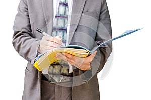 Writing down his ideas. Businessman with a document file in hand