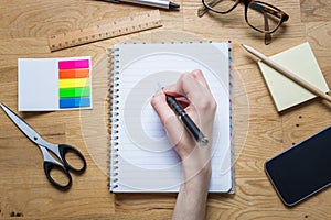 Writing on an empty notepad with pen and other accessories on a