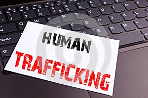 Writing Human Trafficking text made in the office close-up on laptop computer keyboard. Business concept for Slavery Crime Prevent