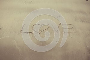 Writing letter love on sand.