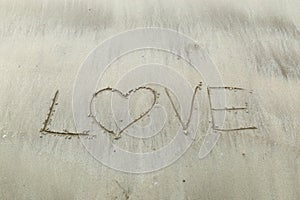 Writing letter love on sand.