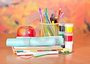 Writing materials, paints and apple photo