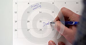 Writing meeting on a calendar agenda date. Mark a deadline on the calendar, schedule appointment to be made as the days