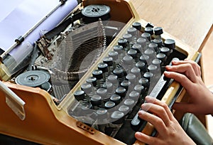 Writing memoirs on an old typewriter - the hands on the keyboard of a typewriter, top view