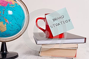 Writing note showing Brand Strategy. Business photo showcasing Long term marketing support for a product Marketing Globe