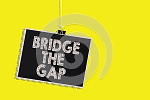 Writing note showing Bridge The Gap. Business photo showcasing Overcome the obstacles Challenge Courage Empowerment Hanging blackb