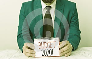 Writing note showing Budget 2020. Business photo showcasing estimate of income and expenditure for next or current year Man holds