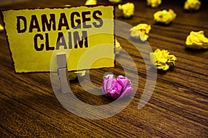 Writing note showing Damages Claim. Business photo showcasing Demand Compensation Litigate Insurance File Suit Clothespin holding