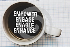 Writing note showing Empower Engage Enable Enhance. Business photo showcasing Empowerment Leadership Motivation Engagement Coffee