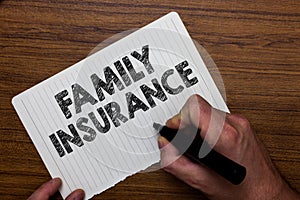 Writing note showing Family Insurance. Business photo showcasing paying a partial or full health care for relatives Man holding m