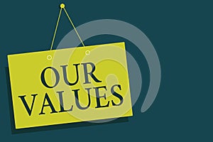 Writing note showing Our Values. Business photo showcasing list of morals companies or individuals commit to do them Yellow board