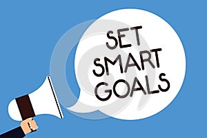 Writing note showing Set Smart Goals. Business photo showcasing Establish achievable objectives Make good business plans Man hold
