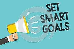 Writing note showing Set Smart Goals. Business photo showcasing Establish achievable objectives Make good business plans Man holdi
