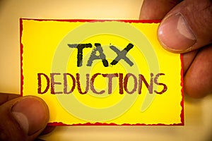 Writing note showing Tax Deductions. Business photo showcasing Reduction on taxes Investment Savings Money Returns Text Words yel
