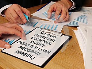 Writing note shows the text Military Reservist Economic Injury Disaster Loan Program MREIDL photo