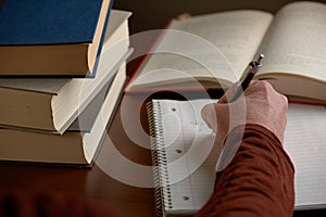 Writing notes with books on desk