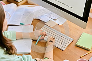 Writing Notes and Studying at Computer Desk