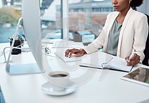 Writing notes, typing on a computer and working at her desk with a corporate and professional business woman. Manager