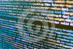Writing programming code on laptop.