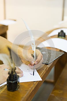 Writing with a quill pen and an ink bottle