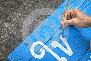 Writing signs board with a brush of watercolors on cement floor background. Painting on wooden board in thai language for advertis