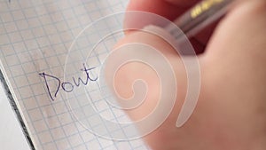 Writing text, extreme close-up of a hand with a pen