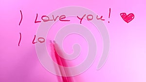 Writing text - I love you. Red felt tip pen on pink background.