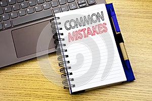 Writing text showing Common Mistakes. Business concept for Common Concept written on notebook book on the wooden background in the