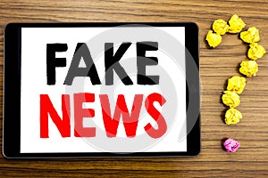 Writing text showing Fake News. Business concept for Hoax Journalism written on tablet computer on the wooden background with ques
