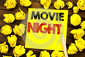 Writing text showing Movie Night. Business concept for Wathing Movies Written on sticky note paper, wooden background with folded