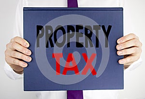 Writing text showing Property Tax. Business concept for Estate Income Taxation written on book notebook paper holding by the man i