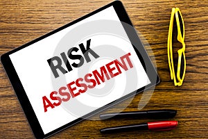 Writing text showing Risk Assessment. Business concept for Safety Danger Analyze Written on tablet laptop, wooden background with