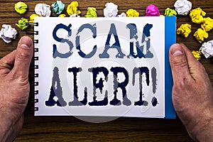 Writing text showing Scam Alert. Business concept for Fraud Warning written on notepad notebook book on the wooden wood background